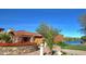 Community entrance with stone accents, colorful flowers, and a glimpse of the tranquil lake at 10206 N 105Th Way, Scottsdale, AZ 85258