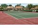 Well-maintained tennis court with net, surrounded by lush greenery, with seating on the side at 10206 N 105Th Way, Scottsdale, AZ 85258