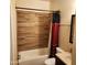 The renovated bathroom features a bathtub, shower and wood look tile at 1126 W Elliot Rd # 1058, Chandler, AZ 85224