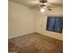 A bright living room features a ceiling fan, large window and neutral-toned carpeting at 1126 W Elliot Rd # 1058, Chandler, AZ 85224