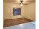 A bright living room features a ceiling fan, large window and neutral-toned carpeting at 1126 W Elliot Rd # 1058, Chandler, AZ 85224