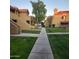 Community walkway between condo buildings with green lawns at 1126 W Elliot Rd # 1058, Chandler, AZ 85224