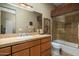 Bathroom with a large mirror, wood vanity, and a glass-enclosed shower at 11501 E Mark Ln, Scottsdale, AZ 85262