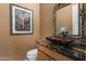 Powder room with granite countertop, vessel sink, and ornate mirror at 11501 E Mark Ln, Scottsdale, AZ 85262