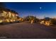 Luxury home with a large driveway and desert landscaping at night at 11501 E Mark Ln, Scottsdale, AZ 85262