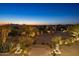 Landscaped front yard with a circular driveway and desert plants at night at 11501 E Mark Ln, Scottsdale, AZ 85262