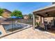 Private backyard featuring a sparkling pool with safety fence and covered patio at 12378 W Roma Ave, Avondale, AZ 85392