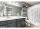 Well-lit bathroom with double sink vanity, decorative shelving, and a shower-tub combo at 12378 W Roma Ave, Avondale, AZ 85392