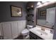 Stylish half-bath featuring a vanity with a sink, a toilet, modern shelving, and attractive decor at 12378 W Roma Ave, Avondale, AZ 85392