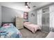 Shared bedroom featuring two twin beds, soft grey walls, and a ceiling fan at 12378 W Roma Ave, Avondale, AZ 85392