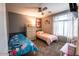 Cozy bedroom featuring two beds, a dresser, a ceiling fan, and a window with patterned curtains at 12378 W Roma Ave, Avondale, AZ 85392