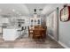 Inviting dining area with wood table and views into kitchen with island seating and decorative shelving at 12378 W Roma Ave, Avondale, AZ 85392