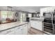 Open kitchen with island, stainless appliances, and eat-in dining leading to living area at 12378 W Roma Ave, Avondale, AZ 85392