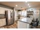 Bright kitchen featuring a breakfast bar and stainless steel fridge at 12378 W Roma Ave, Avondale, AZ 85392