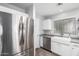 Well-lit kitchen with stainless steel appliances, white cabinetry, and a farmhouse sink at 12378 W Roma Ave, Avondale, AZ 85392