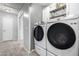 Well-lit laundry room features modern front-load washer and dryer and built-in shelves at 12378 W Roma Ave, Avondale, AZ 85392