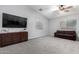 Spacious living room featuring neutral carpeting, a ceiling fan, and large windows at 12378 W Roma Ave, Avondale, AZ 85392