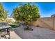 Landscaped backyard with a mature orange tree and patio at 14206 W Mandalay Ln, Surprise, AZ 85379