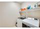 Bright laundry room with washer and dryer and built-in shelving at 14206 W Mandalay Ln, Surprise, AZ 85379