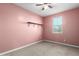 Bedroom with pink walls and ceiling fan at 1523 S 223Rd Dr, Buckeye, AZ 85326