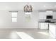 Bright dining room features a modern chandelier and tile floor at 1523 S 223Rd Dr, Buckeye, AZ 85326