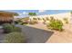 Landscaped backyard with gravel, mature plants, and a covered patio at 18114 W Desert Sage Dr, Goodyear, AZ 85338