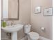 Simple pedestal sink and toilet in a small, updated half-bathroom at 18114 W Desert Sage Dr, Goodyear, AZ 85338