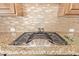 Gas cooktop with granite countertops and backsplash at 18114 W Desert Sage Dr, Goodyear, AZ 85338