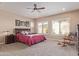 Spacious main bedroom with plush carpeting and a ceiling fan at 18114 W Desert Sage Dr, Goodyear, AZ 85338