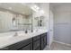 Double vanity bathroom with modern dark brown cabinets and a walk in shower at 1866 N 214Th Ln, Buckeye, AZ 85396