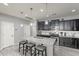 Modern kitchen with dark cabinetry, granite countertops, and an island at 1866 N 214Th Ln, Buckeye, AZ 85396