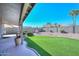 Landscaped backyard with artificial turf, a fountain, and covered patio at 18840 N 83Rd Ln, Peoria, AZ 85382