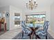 Bright dining room with table and chairs, featuring a large window and chandelier at 18840 N 83Rd Ln, Peoria, AZ 85382