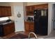 Kitchen with wood cabinets, black appliances, and wine rack at 2425 E Durango Dr, Casa Grande, AZ 85194