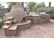 Outdoor kitchen with built-in grill, pizza oven, and stone countertops at 2425 E Durango Dr, Casa Grande, AZ 85194