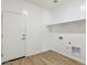 Laundry room with wood flooring, built-in shelving, and a door at 25570 N 154Th Ln, Surprise, AZ 85387