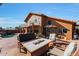 Outdoor patio with firepit and seating area adjacent to the pool and house at 2837 N Whiting Cir, Mesa, AZ 85213