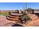 Multi-level patio with seating area, fire pit, and desert landscaping at 2837 N Whiting Cir, Mesa, AZ 85213