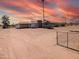 Aerial view of a ranch-style house on a large lot with beautiful sunset sky at 33767 W Grande Rd, Stanfield, AZ 85172