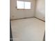 Small bedroom with a window and worn flooring at 33767 W Grande Rd, Stanfield, AZ 85172