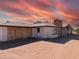 Ranch-style home with boarded-up garage and desert landscape at 33767 W Grande Rd, Stanfield, AZ 85172