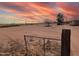 Large lot with chain link fence and desert landscape at sunset at 33767 W Grande Rd, Stanfield, AZ 85172