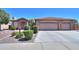 House exterior featuring a three-car garage and stone accents at 3818 N Kalispell Ct, Casa Grande, AZ 85122