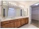 Double vanity bathroom with wood cabinets at 4116 E Sunnyside Dr, Phoenix, AZ 85028