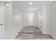 Hallway with light-colored wood floors, neutral walls, and a white front door with glass insert at 4220 W State Ave, Phoenix, AZ 85051