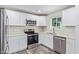 Well lit kitchen featuring stainless steel appliances, white cabinets, and light countertops at 4220 W State Ave, Phoenix, AZ 85051