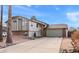 Two-story home with a long driveway, two-car garage, brick accents, and mature palm trees at 4947 E Adobe St, Mesa, AZ 85205