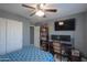 Bedroom with ceiling fan, large window, and gaming setup at 5175 W Warren Dr, Casa Grande, AZ 85194