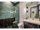 Contemporary bathroom with walk-in shower, dark tile, and gold fixtures at 5712 E Calle Camelia --, Phoenix, AZ 85018