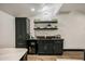 Modern wet bar with dark cabinetry and floating shelves at 5712 E Calle Camelia --, Phoenix, AZ 85018